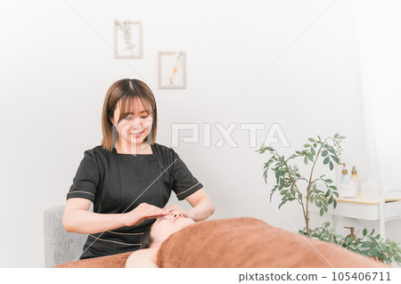 Asian therapist massaging forehead and forehead in beauty salon Asian therapist massaging forehead and forehead in beauty salon 105406711