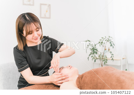 Asian woman of esthetician who does facial beauty treatment (face line) Asian woman of esthetician who does facial beauty treatment (face line) 105407122