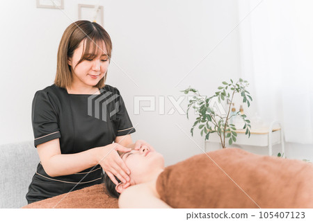 Asian woman of esthetician who does facial beauty treatment (forehead) 105407123