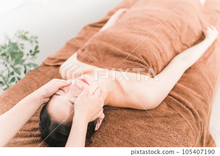A woman undergoing facial esthetics and small face correction treatment at an esthetic salon A woman undergoing facial esthetics and small face correction treatment at an esthetic salon 105407190