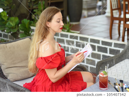Beautiful blonde woman artist and illustrator thinking about idea of a drawing, sitting on a couch 105407342