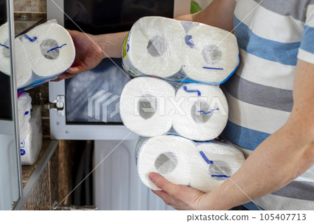 A man stocking up toilet paper at home. Crisis product lack concept 105407713
