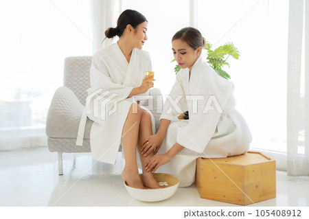 Group women friends relaxing enjoy and spa foot massage put on bathrobe in modern room. Group women friends relaxing enjoy and spa foot massage put on bathrobe in modern room. 105408912