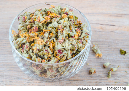 The Flower tea. Dried of apple blossom in glass cup on wooden table. 105409396