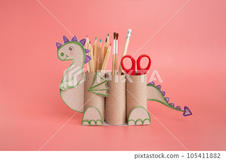 dragon shape a pencil holder made out of toilet paper and a pair of scissors, educational and craft activity dragon shape a pencil holder made out of toilet paper and a pair of scissors, educational and craft activity 105411882