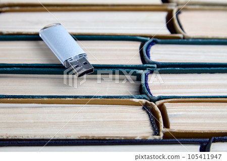 Usb flash drive on stack of paper old books. Keepers and carriers of information from different eras 105411947