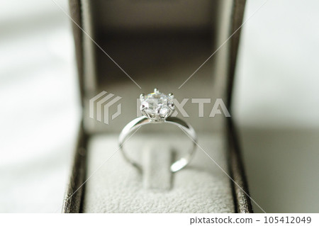 Diamond ring with jewelry gift box on white fabric background Diamond ring with jewelry gift box on white fabric background 105412049