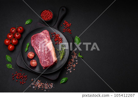 Fresh raw beef striploin steak with salt, spices and herbs 105412207
