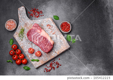 Fresh raw beef striploin steak with salt, spices and herbs 105412223
