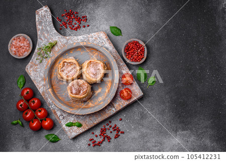 Delicious baked meat roll wrapped in bacon with salt, spices and herbs 105412231
