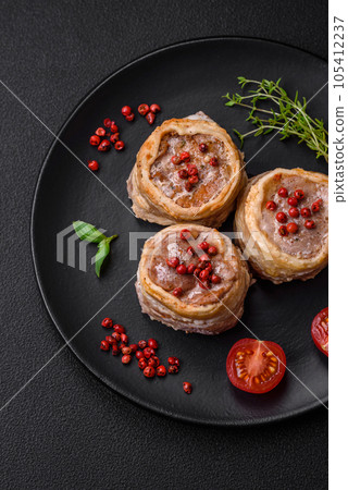 Delicious baked meat roll wrapped in bacon with salt, spices and herbs Delicious baked meat roll wrapped in bacon with salt, spices and herbs 105412237