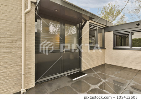 an outside area with a black door and white trim on the side of a house that is made of stone an outside area with a black door and white trim on the side of a house that is made of stone 105412603