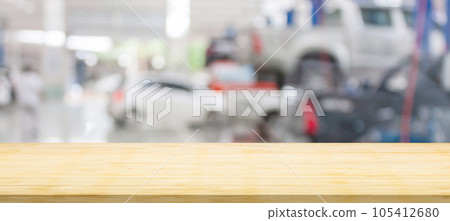 Empty wood table top with car service centre auto repair workshop blurred background 105412680