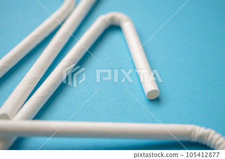 Biodegradable eco friendly white paper drinking straw on blue background Biodegradable eco friendly white paper drinking straw on blue background 105412877