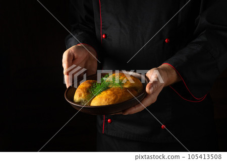 The chef serves baked dill pies in a bowl. Free black space for menu or recipe. 105413508