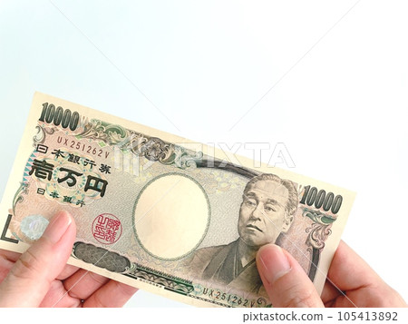 A woman's hand holding a 10,000 yen bill with both hands A woman's hand holding a 10,000 yen bill with both hands 105413892