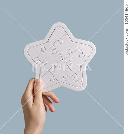 Hand holding star-shaped puzzle for review, feedback concept 105414669