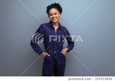 a young woman with dark skin and black hair is dressed in a blue genim suit a young woman with dark skin and black hair is dressed in a blue genim suit 105414699