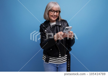 smart 60s modern middle-aged woman grandmother with gray hair makes an order on the Internet using a smart 60s modern middle-aged woman grandmother with gray hair makes an order on the Internet using a 105414789