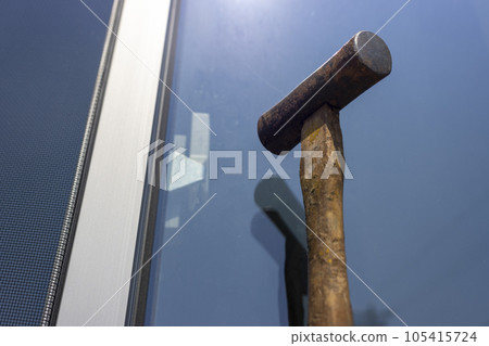 Image of breaking a window glass with a hammer 105415724