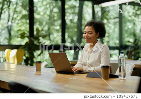 Satisfied smiling woman office worker looking at laptop screen 105417675