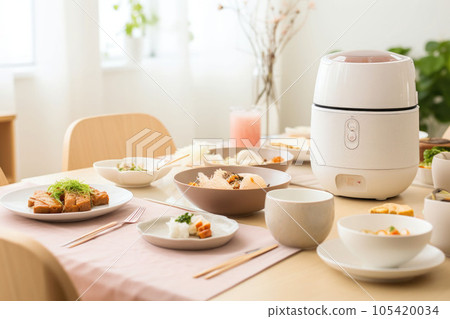 A minimalist bright kitchen with a rice cooker and dishes on top of the dining table. Generative AI A minimalist bright kitchen with a rice cooker and dishes on top of the dining table. Generative AI 105420034