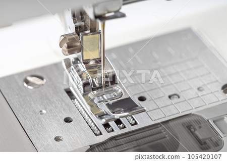 Modern white sewing machine presser foot closeup, macro Modern white sewing machine presser foot closeup, macro 105420107