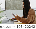 Young asian woman using smartphone and laptop at home. 105420242