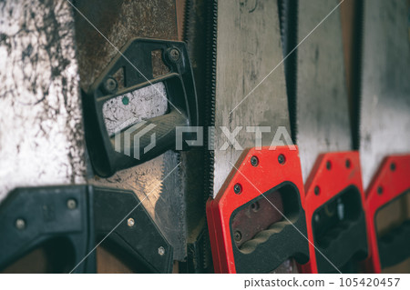 closeup old used rust hand saw sharp teeth for heavy duty wood cut home diy tool hang in workshop. 105420457