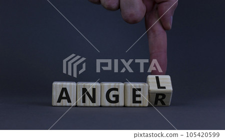 Having anger or being an angel. Businessman turns a wooden cube and changes the word anger to angel. Beautiful grey background. Business and anger or angel concept. Copy space. Having anger or being an angel. Businessman turns a wooden cube and changes the word anger to angel. Beautiful grey background. Business and anger or angel concept. Copy space. 105420599