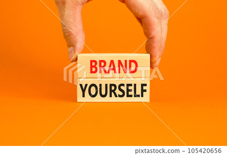 Brand yourself symbol. Concept words Brand yourself on beautiful wooden block. Beautiful orange table orange background. Businessman hand. Business brand yourself concept. Copy space. 105420656