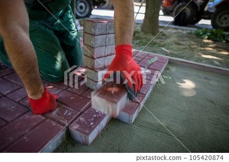 Paving work for laying a new pedestrian path is being done in the summer. 105420874