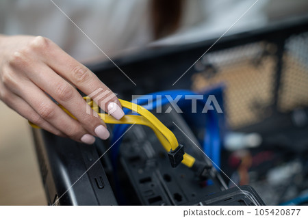 Close-up of a woman's hand holding computer cables Close-up of a woman's hand holding computer cables 105420877