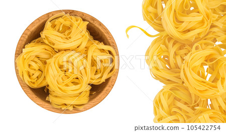 Raw tagliatelle pasta in wooden bowl isolated on white background with full depth of field. Top view. Flat lay 105422754
