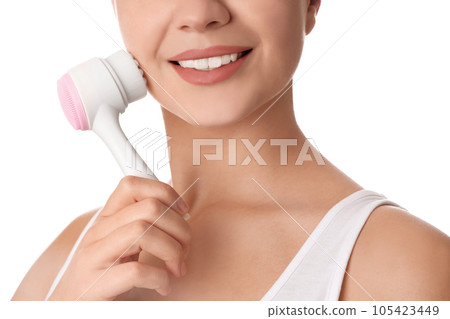 Young woman washing face with cleansing brush on white background, closeup. Cosmetic product 105423449