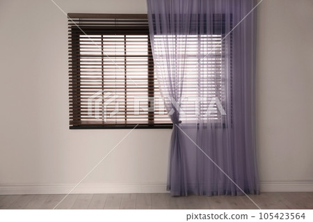Window with beautiful curtain and blinds in empty room 105423564