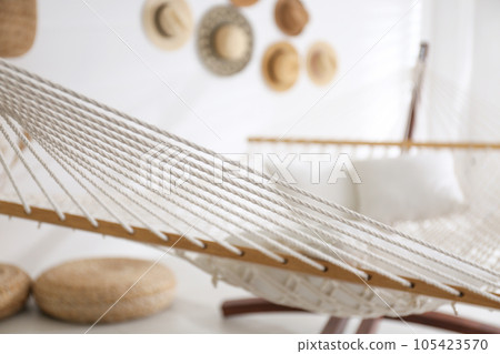 Comfortable hammock with pillows in stylish room. Interior design 105423570