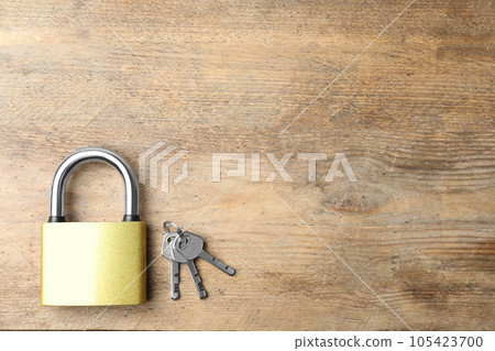 Steel padlock and keys on wooden background, top view with space for text. Safety concept 105423700