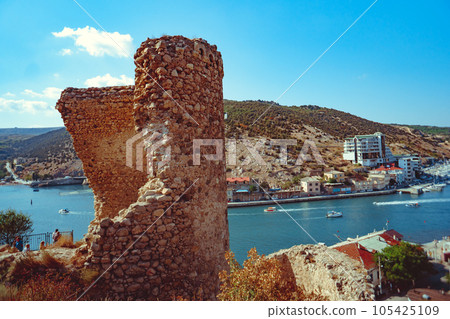 an ancient stone tower on a blue sky background an ancient stone tower on a blue sky background 105425109