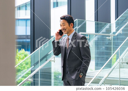 中年商務人士在辦公室用智能手機交談 中年商務人士在辦公室用智能手機交談 105426036