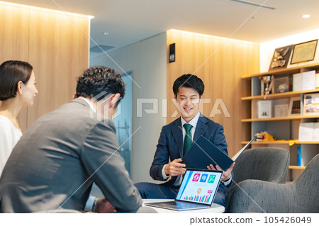 A middle-aged couple and a counselor having a conversation in the lobby 105426049