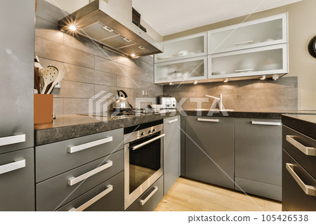 a modern kitchen with black counter tops and white trim on the cabinets in this photo is taken from an angle 105426538