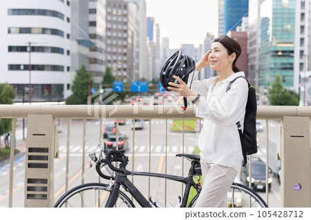 戴著自行車頭盔的阿拉菲女士一邊打理頭髮 戴著自行車頭盔的阿拉菲女士一邊打理頭髮 105428712