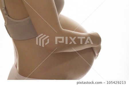 Pregnant woman putting her hand on her stomach Pregnant woman putting her hand on her stomach 105429213