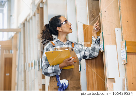 staff working in wood furniture industry factory checking selecting plywood wooden board type material in stock warehouse. 105429524