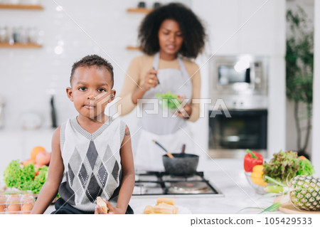 happy african black young mother with her boy lovely cute cooking together at home holiday activity 105429533