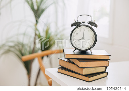 old bell clock on stack books, times for learning reading education remind concept. old bell clock on stack books, times for learning reading education remind concept. 105429544