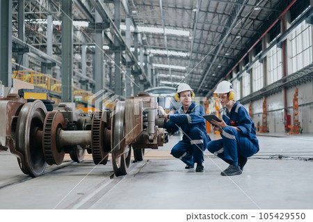 Engineer team working maintenance service fix replace train wheel in locomotive train repair depot. Engineer team working maintenance service fix replace train wheel in locomotive train repair depot. 105429550