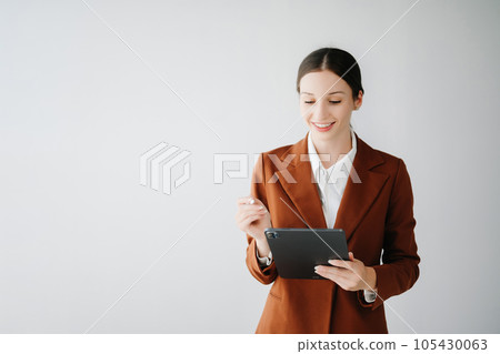 Smiling caucasian young businesswoman bank employee worker manager boss ceo looking at camera, using tablet, laptop and notepad online isolated in white background. Smiling caucasian young businesswoman bank employee worker manager boss ceo looking at camera, using tablet, laptop and notepad online isolated in white background. 105430063
