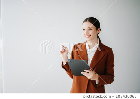 Smiling caucasian young businesswoman bank employee worker manager boss ceo looking at camera, using tablet, laptop and notepad online isolated in white background. Smiling caucasian young businesswoman bank employee worker manager boss ceo looking at camera, using tablet, laptop and notepad online isolated in white background. 105430065